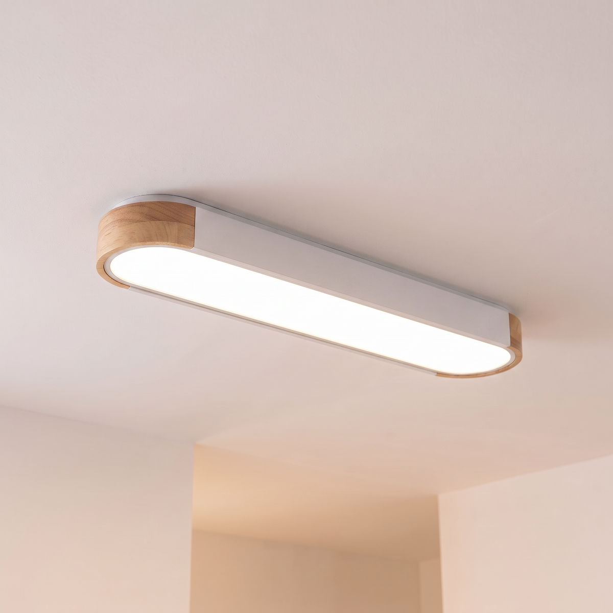 Imogen oval LED ceiling light, white 95 cm, oak wood ends, warm light on a white ceiling