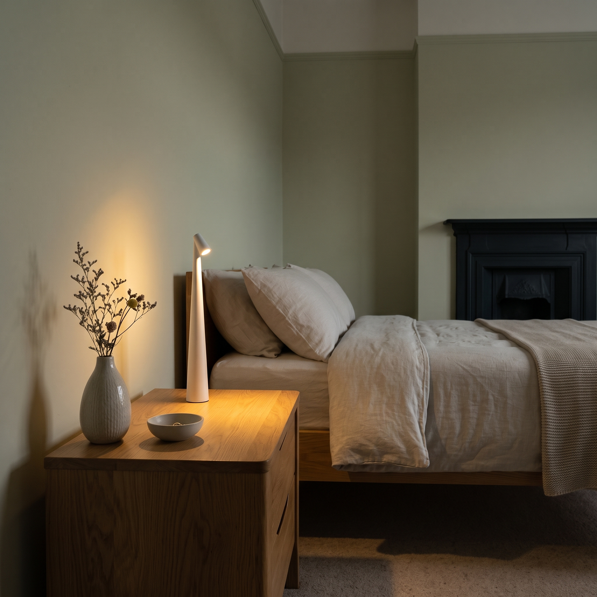Nola cordless LED table lamp – glowing beside a bed
