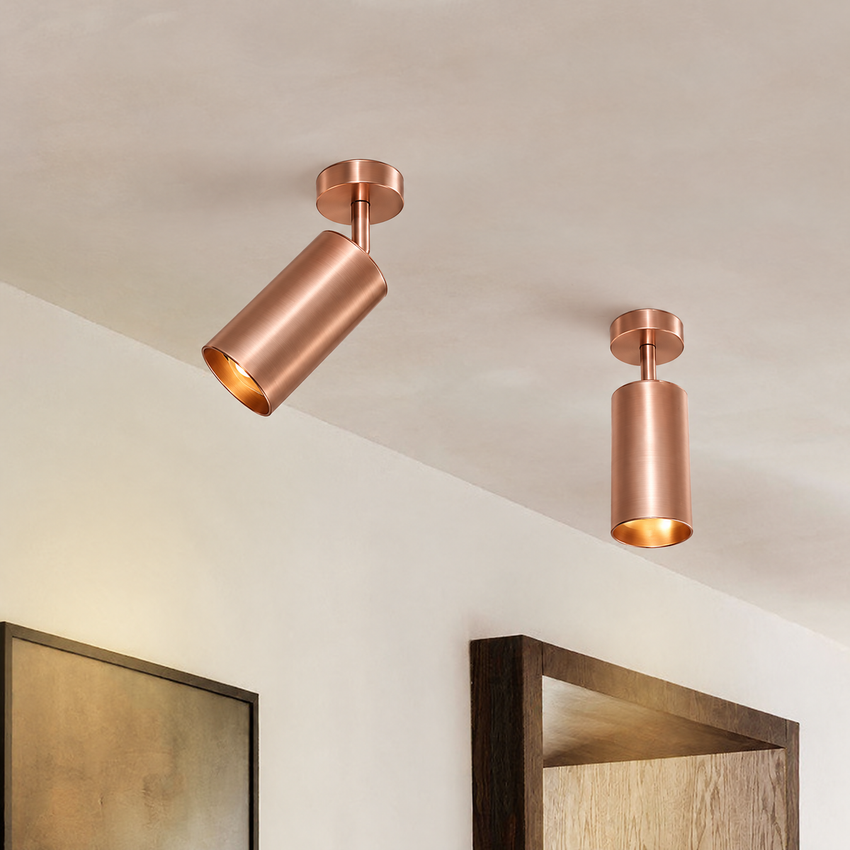 Remy adjustable spot ceiling light – pair in rose bronze by a mirror