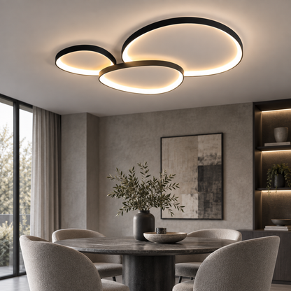 Three Linara flush mount ceiling lights in black, set close together so their rings overlap above a round dining table