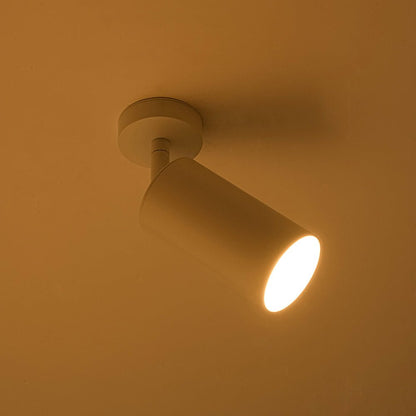 Remy adjustable spot ceiling light – lit with a warm glow