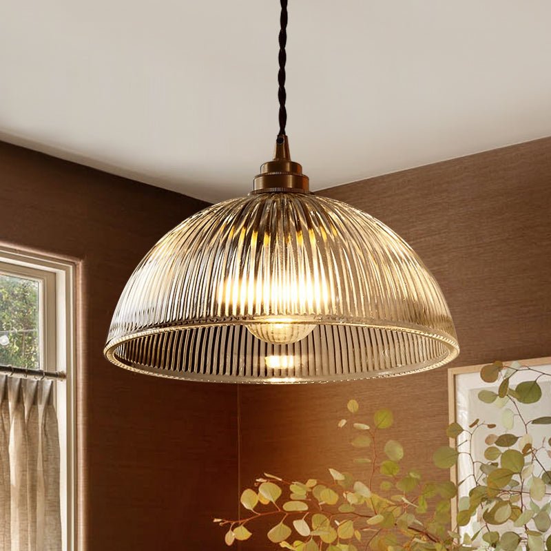 Eleonora ribbed glass pendant light – lit against a wooden wall